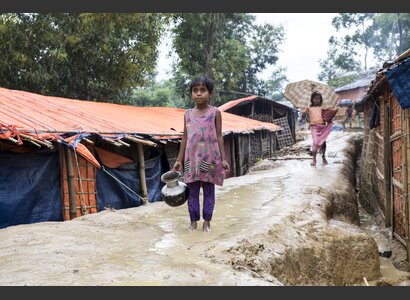 Ein kleines Rohingya-Mädchen, das Wasser im Regen holt. | © Helvetas / Patrick Rohr